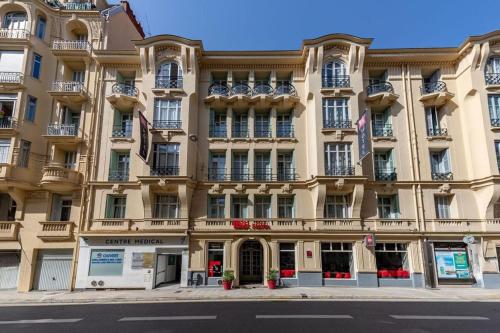 - un grand bâtiment dans une rue de la ville dans l'établissement ibis Nice Centre Notre Dame, à Nice