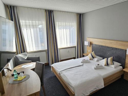 ギュンツブルクにあるHotel Hirsch Günzburgのベッドとテーブルが備わるホテルルームです。