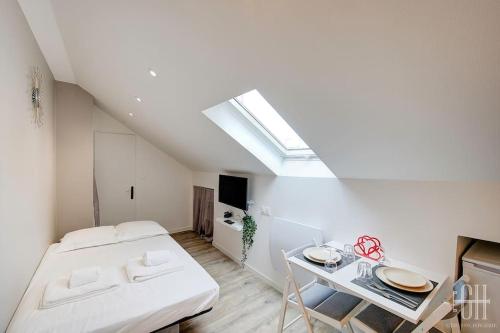 une chambre blanche avec un lit et une table dans l'établissement Sakura - Face Gare, à Tours