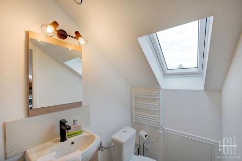 une salle de bain avec un lavabo et un miroir et des toilettes dans l'établissement Sakura - Face Gare, à Tours