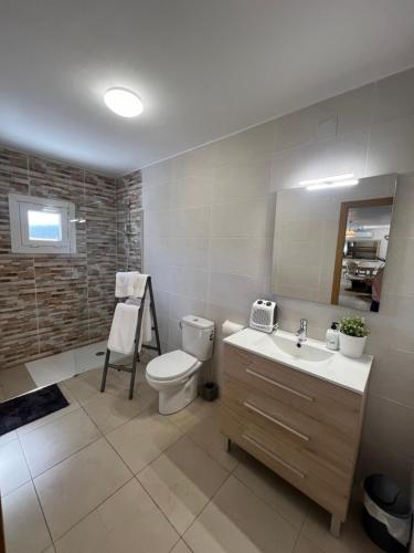 uma casa de banho com um WC e um lavatório em Apartamento loft, jardín y piscina privada em Romanyá de la Selva