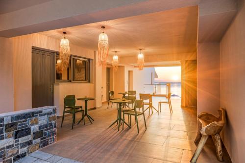 a living room with tables and chairs and a dining room at 8MOONS Elegant Apartments in Kokkari