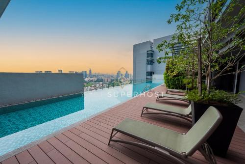 a row of lounge chairs sitting on a rooftop at Millerz Square Near MidValley by YourSuperhost in Kuala Lumpur