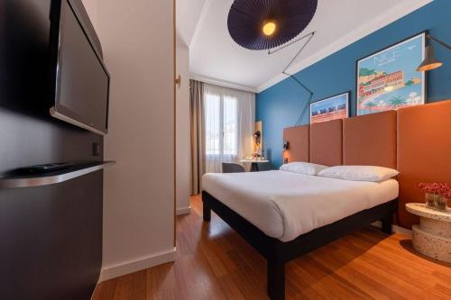 1 dormitorio con 1 cama y TV de pantalla plana en ibis Nice Centre Notre Dame, en Niza