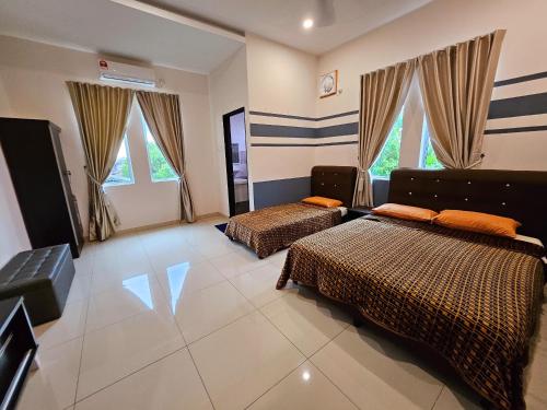 a bedroom with two beds and a couch and windows at The Blue Guest House, Parking, Aulong in Taiping
