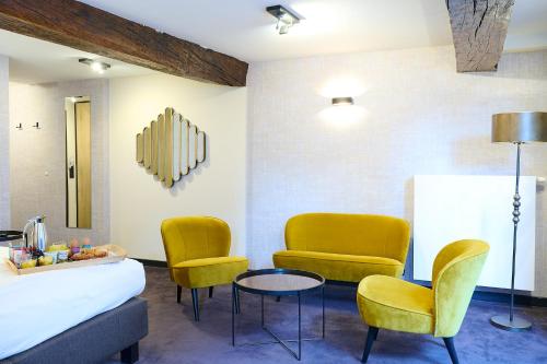 a room with two chairs and a bed and a table at Les Tanneurs in Namur
