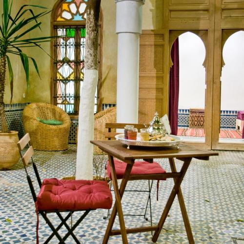 a table and two chairs in a room at Riad La Maison D'à Côté in Meknès