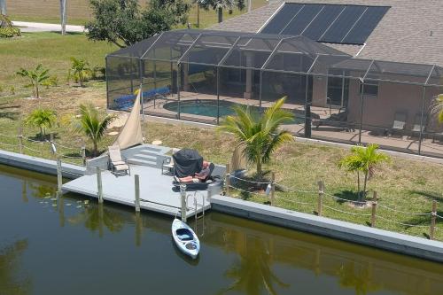 un barco en el agua junto a una casa en Wildlife Views & Fishing Villa, en Cabo Coral