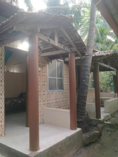 a house with a porch and a bed in it at Silver sea in Gokarna