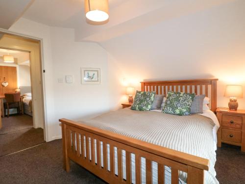 a bedroom with a wooden bed with two pillows at Roaches View Barn in Stoke on Trent