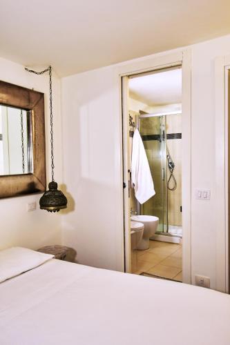 Perugia-Apartments Via della Gabbia في بيروجيا: غرفة نوم بسرير وحمام مع دش