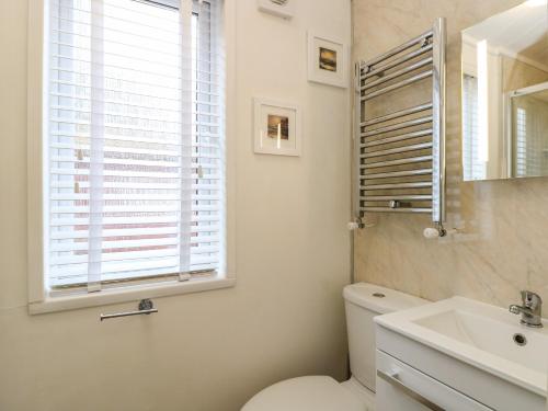 a bathroom with a toilet and a sink and a window at Shoreside Lodge in Bowness-on-Windermere