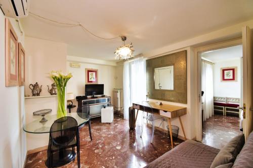 Perugia-Apartments Via della Gabbia في بيروجيا: غرفة معيشة مع طاولة زجاجية ومكتب