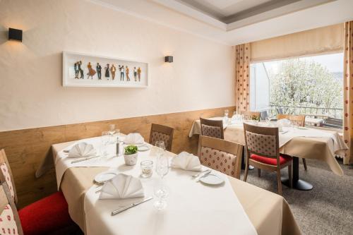 a restaurant with white tables and chairs and a window at Hotel Kammerer in Sankt Georgen im Schwarzwald