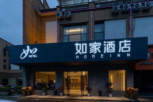 un edificio con un cartel en la parte delantera en Home Inn Zhangjiajie Tianmen Mountain Branch, en Zhangjiajie