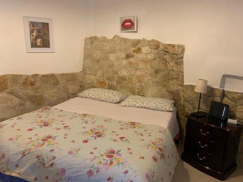 ein Schlafzimmer mit einem Bett mit einer Steinmauer in der Unterkunft Charming Old Town House in Bari