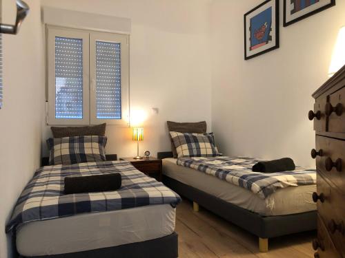a bedroom with two beds and a nightstand and two windows at Casa the Dutchman in Navarrés