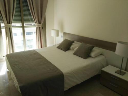 a bedroom with a large white bed and a window at Zenit in Santa Cruz de Tenerife