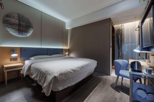 a bedroom with a bed and a desk and a chair at Home Inn Zhangjiajie Tianmen Mountain Branch in Zhangjiajie