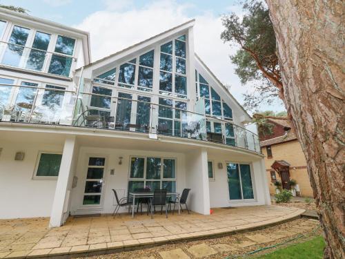 a house with a balcony with a table and chairs at 5 Red Sails in Poole