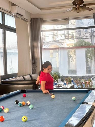 a young girl playing pool on a pool table at Minh Phước Villa 12 Kim Ngân in Vung Tau
