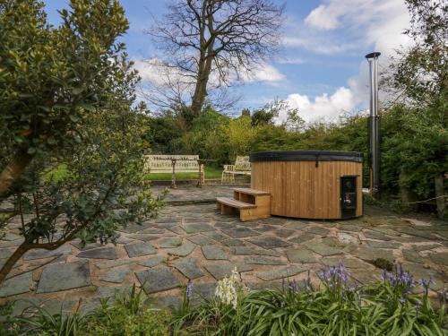 a wooden outhouse with a bench in a garden at Eden Vale in Broughton in Furness