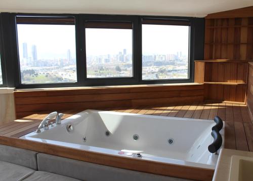 a large bath tub in a room with windows at Aram Otel Business & Luxury in Istanbul