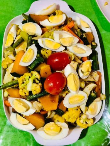 a plate of food with eggs and vegetables on a table at Lotus cool hotel and restaurant in Ibbagomuwa