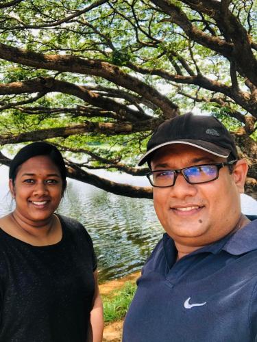 a man and a woman standing in front of a lake at Lotus cool hotel and restaurant in Ibbagomuwa