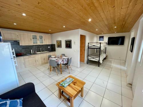 ein Wohnzimmer mit einem Tisch und einer Küche in der Unterkunft Maison de la Plage in Le Barcarès