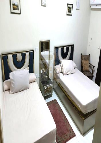 a bedroom with two beds and a mirror at فيلا رائعه في الساحل الشمالي مارينا 6 اطلاله بحر in El Alamein