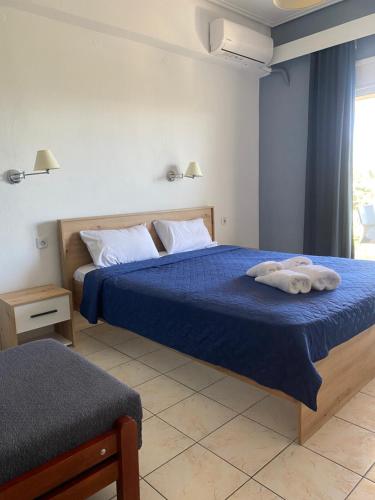 Un dormitorio con una cama azul con toallas. en Hotel Kalloni, en Volos