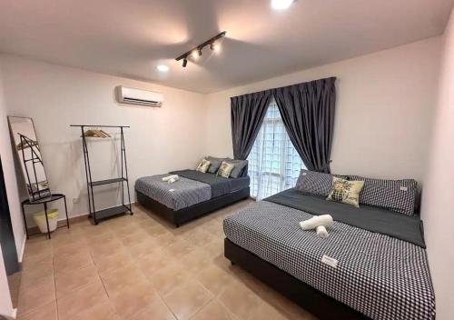a bedroom with two beds and a window at A'famosa Bungalow Villa 859 in Kampong Alor Gajah