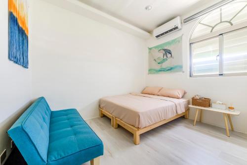 a bedroom with a bed and a blue chair at Ocean Diary Hostel in Green Island