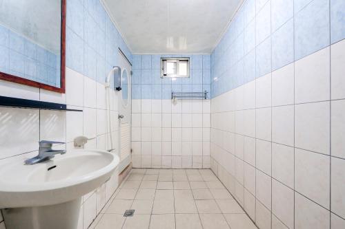 a white bathroom with a sink and a shower at Ocean Diary Hostel in Green Island