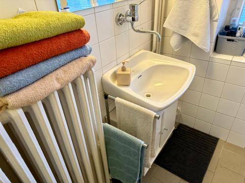 uma casa de banho com uma pilha de toalhas ao lado de um lavatório em Epic apartment in the City Center em Praga