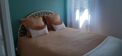 a bed with two pillows on it in a bedroom at Les jardins de la Tournette, entre lac et montagnes, appartement charmant avec terrasse et jardin in Saint-Jorioz