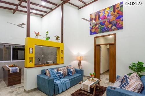 a living room with two blue couches and a tv at EKOSTAY - Sierra Villa in Alibaug