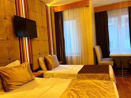 a hotel room with two beds and a flat screen tv at Taksim Cetinkaya Suite in Istanbul