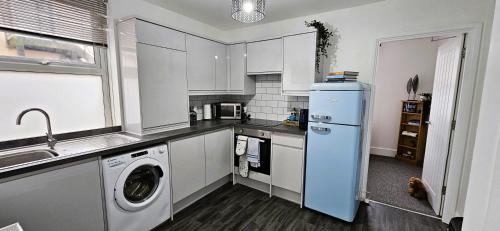 a kitchen with white cabinets and a washer and dryer at Spacious 2 Bed Flat in Central Plymouth in Plymouth
