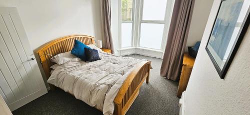 Un dormitorio con una cama con almohadas azules. en Spacious 2 Bed Flat in Central Plymouth, en Plymouth
