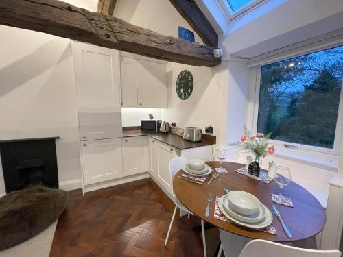 a kitchen with a wooden table and a dining room at Pheasants Crossing - luxurious and cozy cottage in peaceful rural location in Almondbury