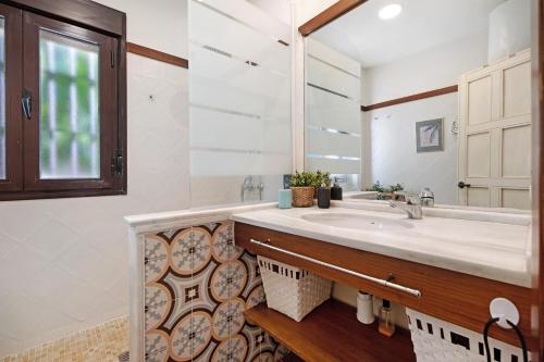 W łazience znajduje się umywalka i lustro. w obiekcie Casa Dos Mares w Kadyksie