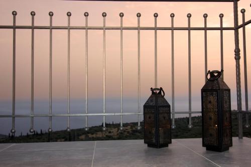 a couple of candles sitting on top of a fence at Lithorama Residence Mani Complex in Koúmani