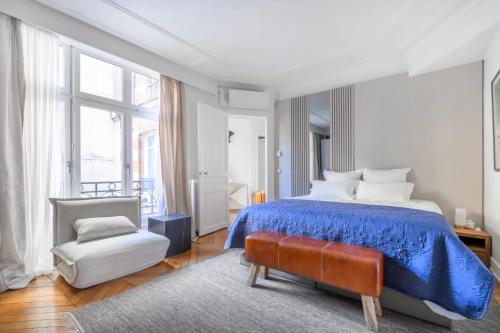 - une chambre avec un lit bleu et une chaise dans l'établissement Trocadéro Signature, à Paris