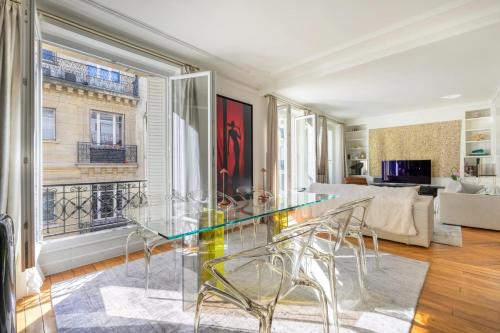 une salle à manger avec une table en verre et un salon dans l'établissement Trocadéro Signature, à Paris