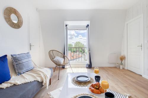 un salon avec un canapé et une table dans l'établissement Escale en bord de seine - vue seine - Tour Eiffel, à Villeneuve-la-Garenne