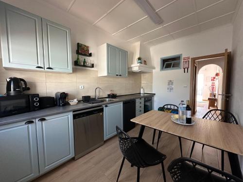 a kitchen with a table and a table and chairs at Pátio 7 & Meio DiscoverAlentejo in Moura