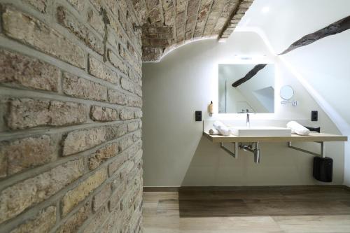 a bathroom with a stone wall and a sink at Les Tanneurs in Namur