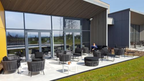a person sitting on a patio outside of a building at Best Western Plus Hotel & Restaurant Les Humanistes Colmar Nord in Sélestat